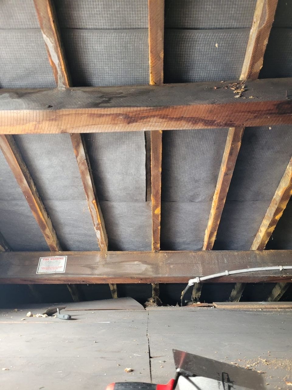 The same roof space after remediation, with the rafters cleaned back and the membrane clear across the bays