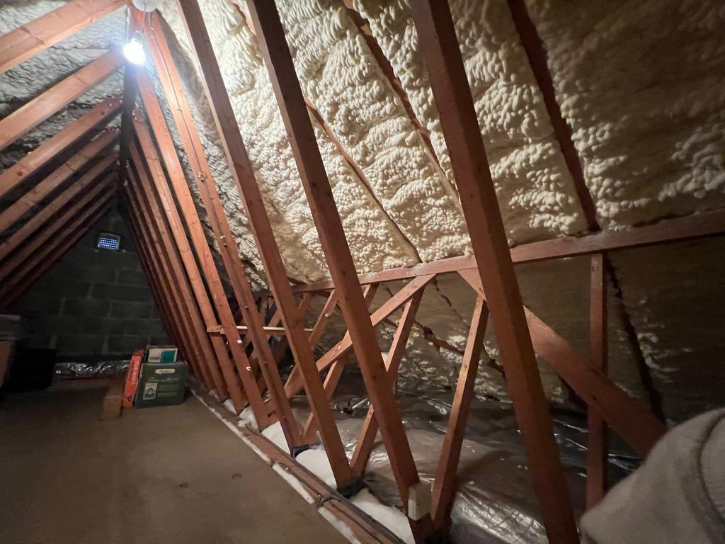 Loft before spray foam removal – foam-covered rafters