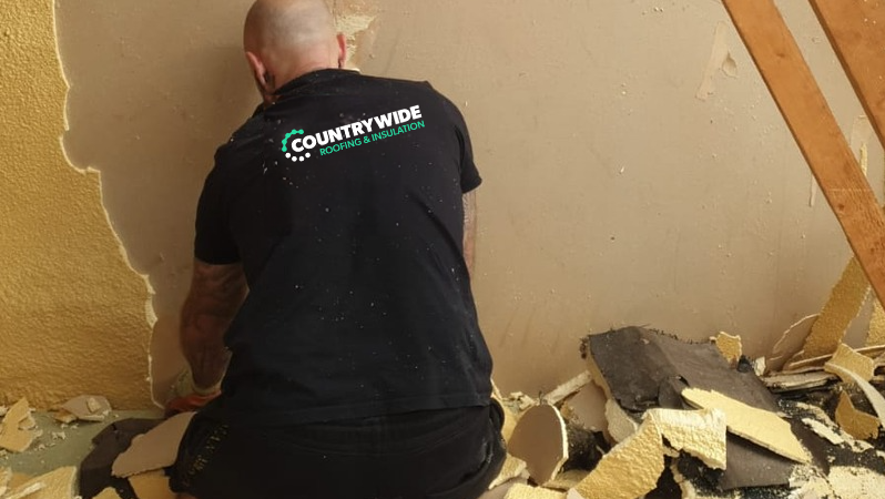 Spray foam removal team working on roof rafters