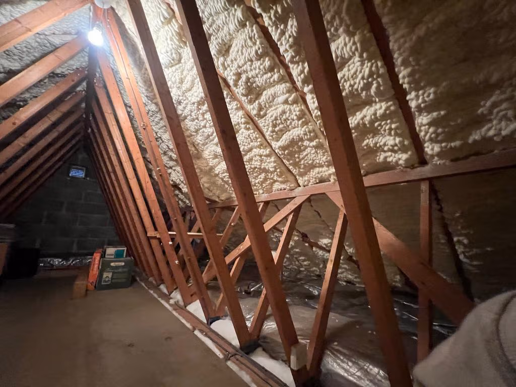 Loft before spray foam removal – foam-covered rafters