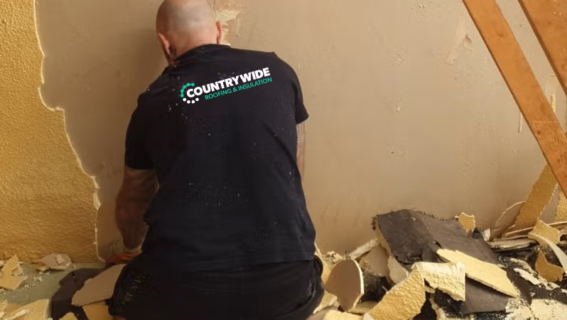Spray foam removal team working on roof rafters