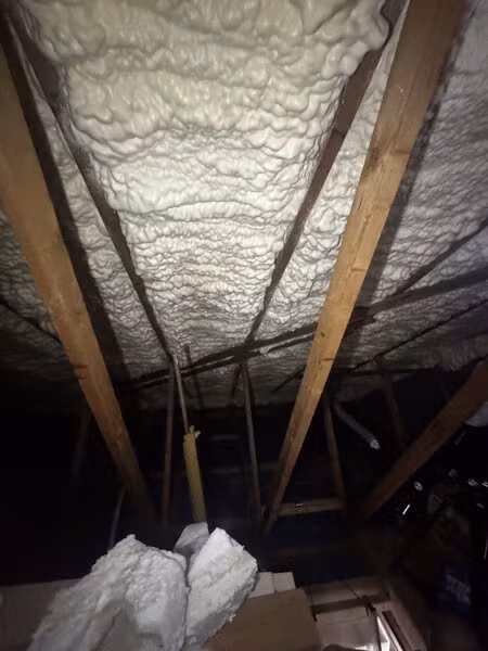 Spray foam covering the underside of the roof before removal