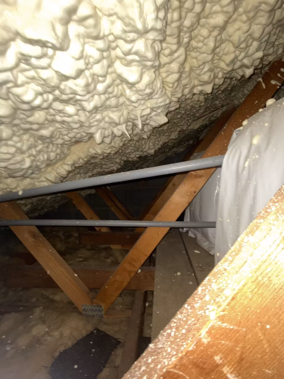 Open-cell spray foam on the underside of the roof before removal