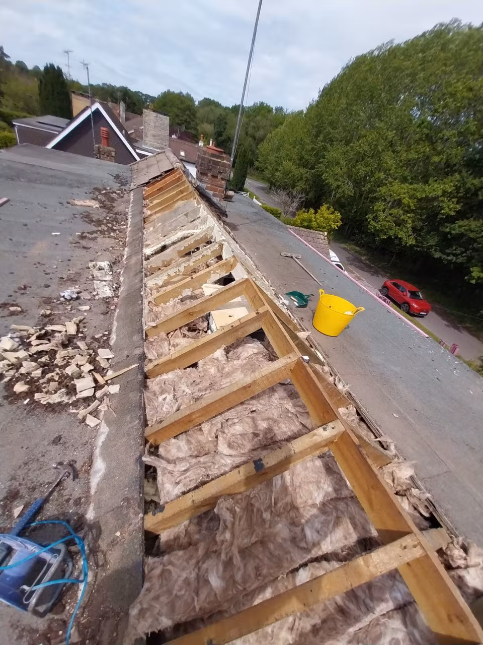 Roof stripped to the rafters during replacement, viewed from the scaffolding